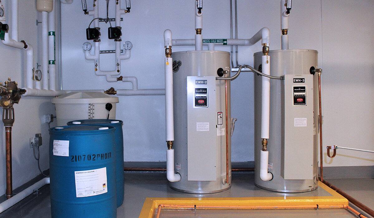 Mechanical room with EWH-2 / EWH-3 electric water heaters and glycol drum