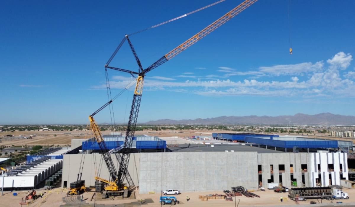 Data-center shell under construction with crawler crane, desert site