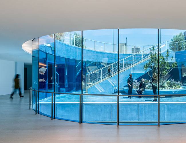 Finished curved blue-glass atrium interior with feature stair