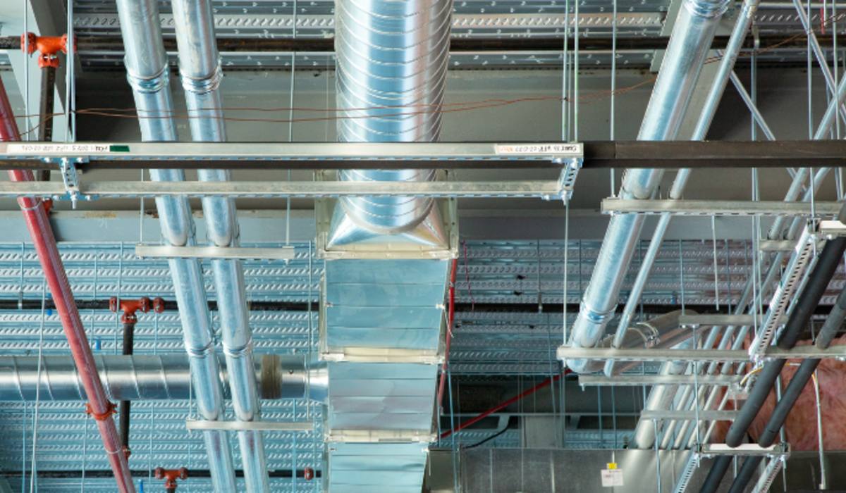 Coordinated overhead multi-trade rack — round duct, hydronic, sprinkler